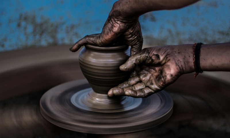 Skilled hands shaping a pot on a pottery wheel